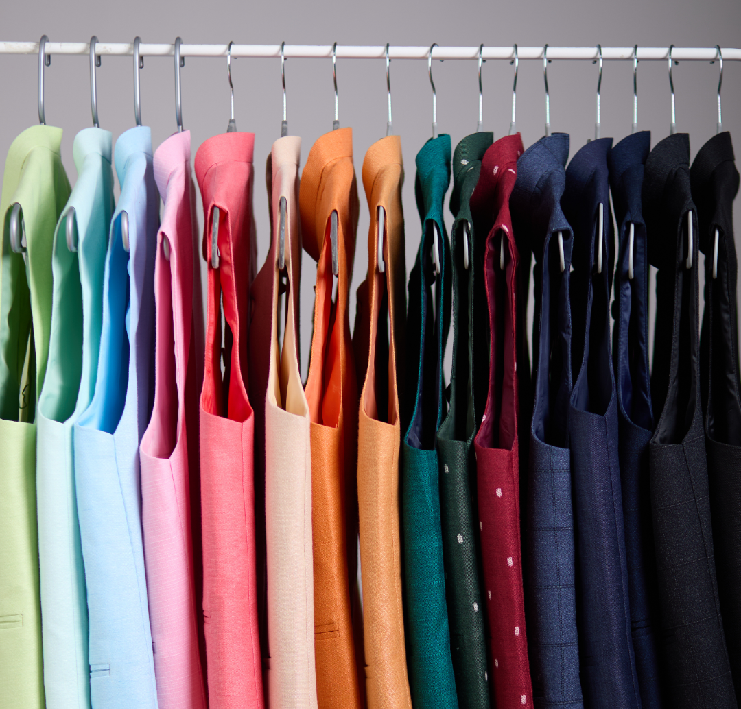 Colorful shirts on hangers against a gray background